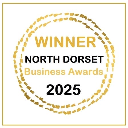 A gold circular stamp with the text "WINNER North Dorset Business Awards 2025" in the center on a white background.